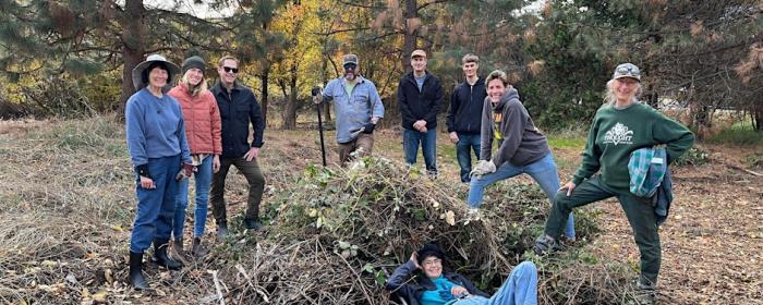 A crew poses for a picture as the clean trees in a local park.