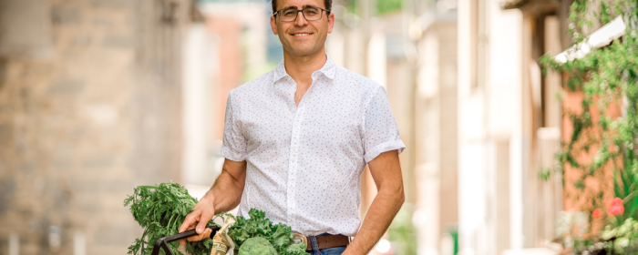 Jon Steinman poses with a grocery basket as a headshot. 