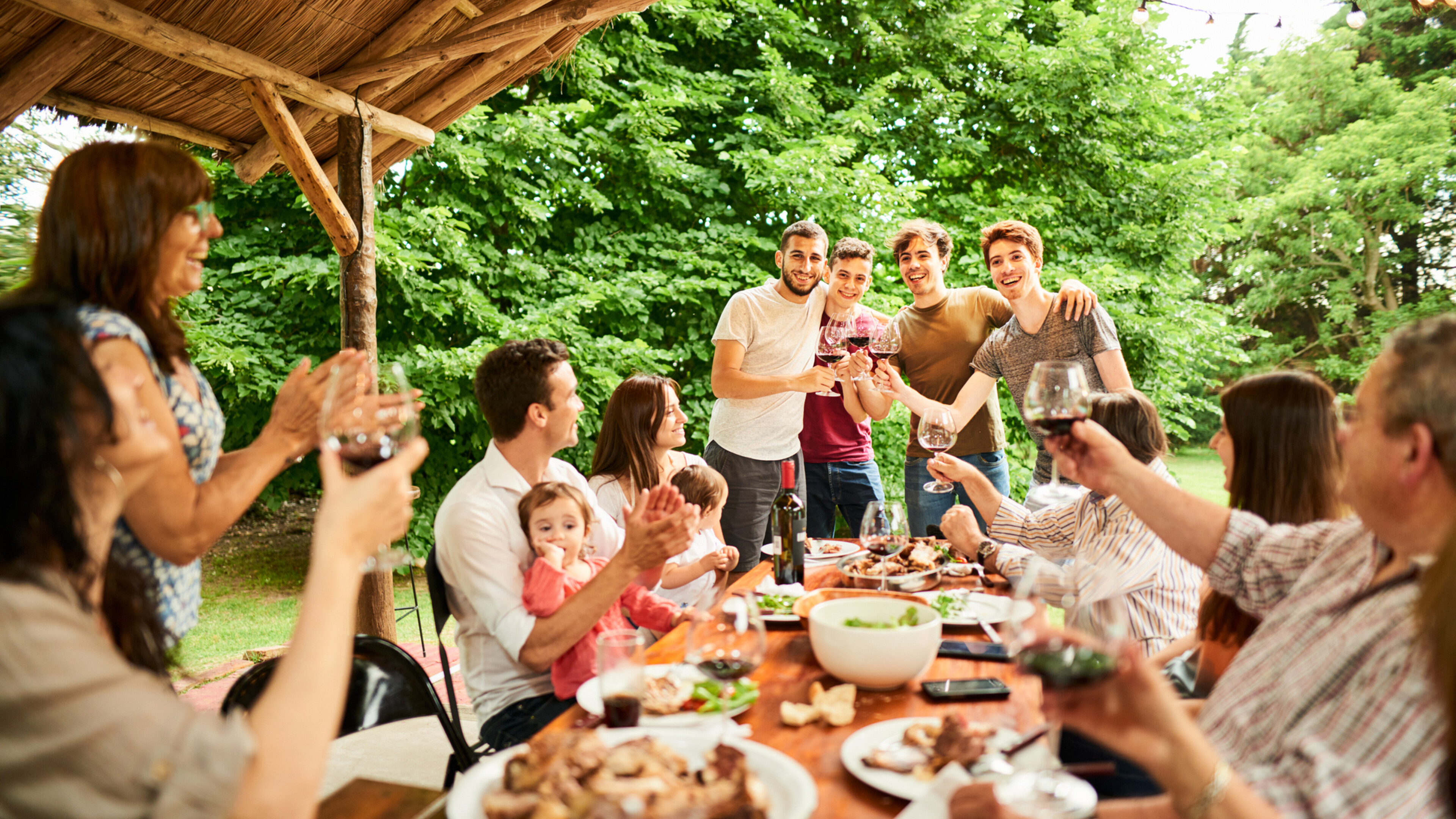 large family celebrating with food and wine