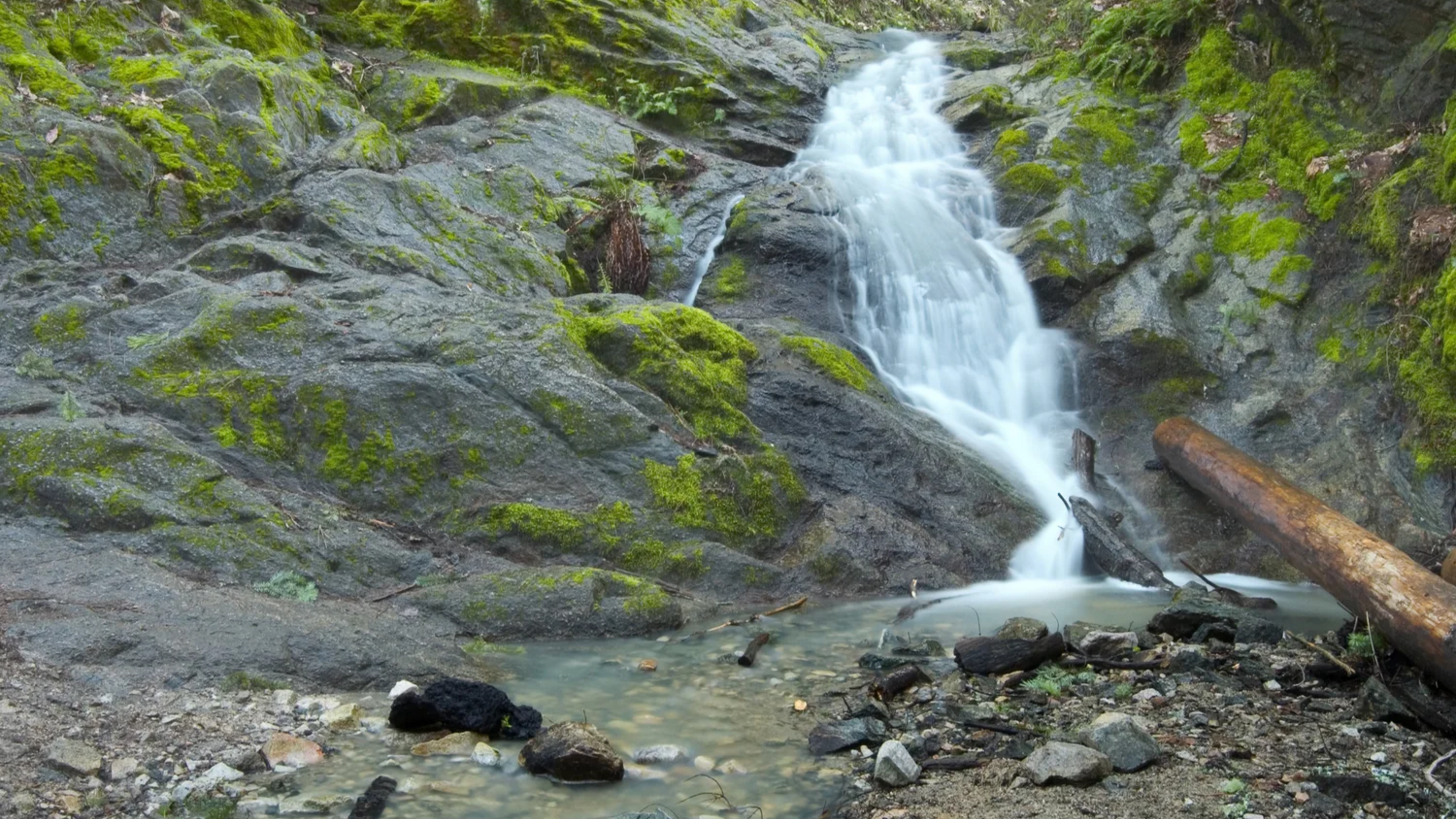 small waterfall emptying into a small pond
