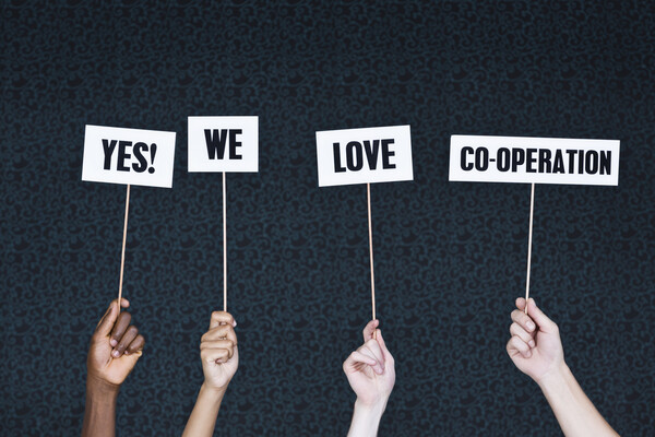 hands holding signs that say yes we love cooperation