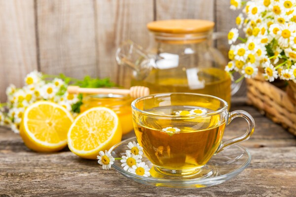 chamomile tea in a clear cup with lemons in the background