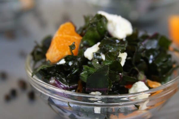 kale orange salad in a clear glass bowl