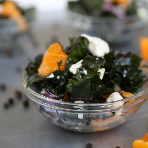 kale orange salad in a clear glass bowl