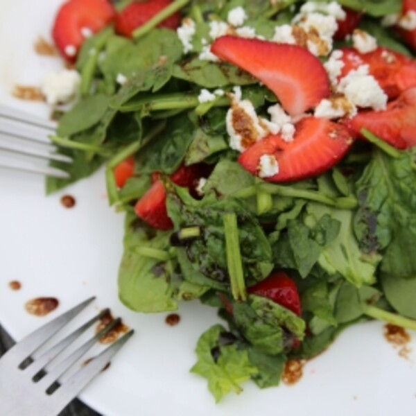 strawberry spinach and feta salad on a white plate